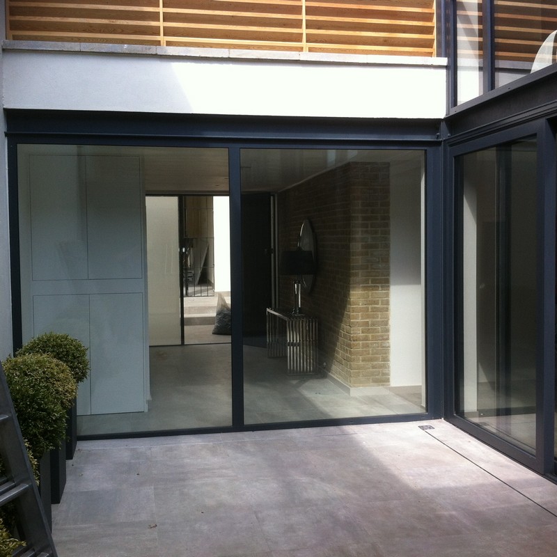 Floor-to-ceiling sliding doors opening to courtyard in Totteridge