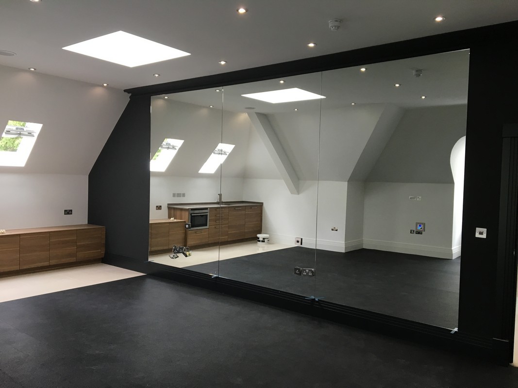 Frameless glass wall dividing loft conversion in Totteridge